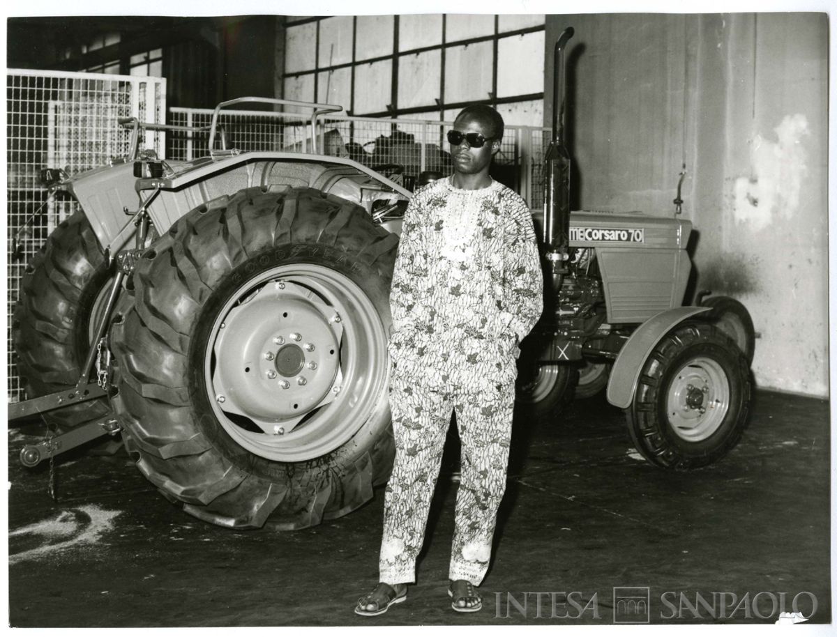Visita alla SAME di borsista n.i. ritratto davanti ad un trattore, ante 1977 (Foto Attualità di Leoni e Cesni)