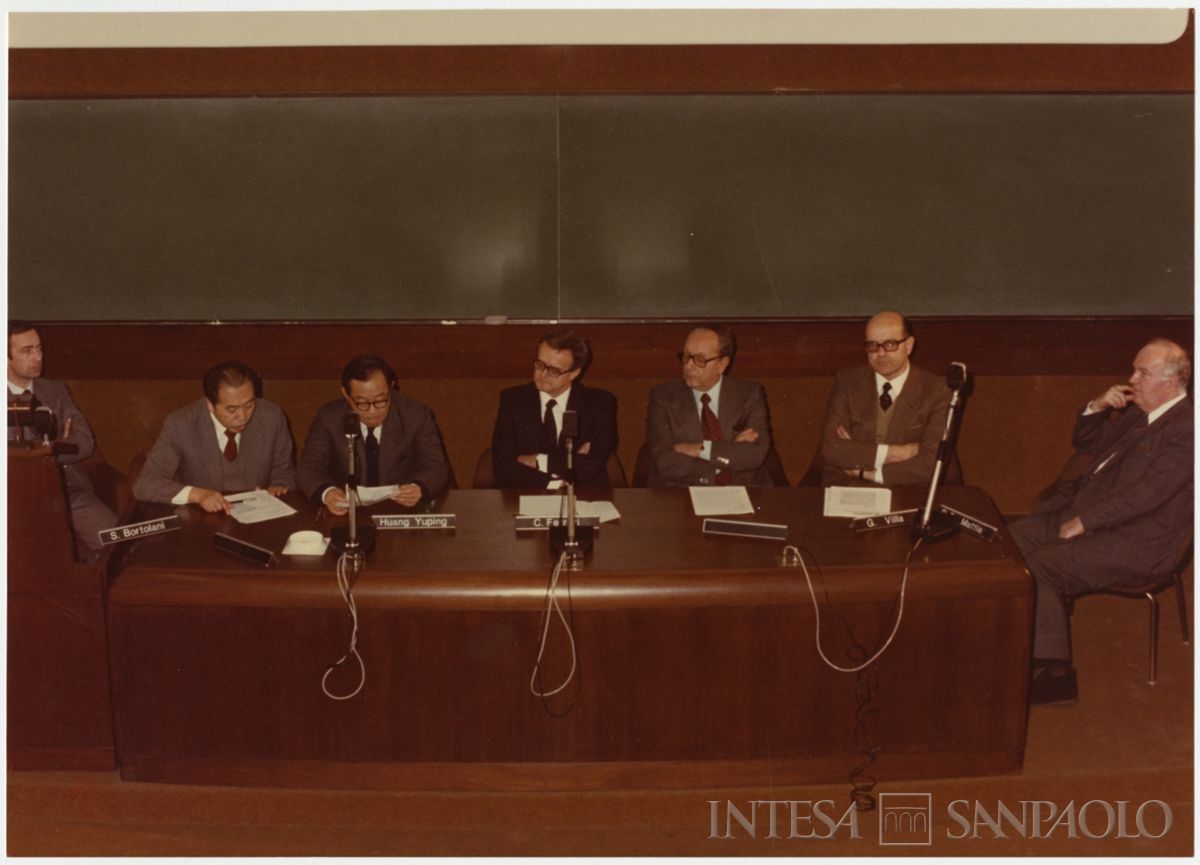 Discorso del Governatore della Banca Centrale della Cina Huang Yuping durante la sua visita: si riconoscono al tavolo dei relatori Bortolani Sergio, primo da sinistra, Huang Yuping, terzo da sinistra, Camillo Ferrari, quarto da sinistra, Giuseppe Villa, secondo da destra, Carlo Polli, terzo da destra, 17 gennaio 1983 (Mario La Porta)