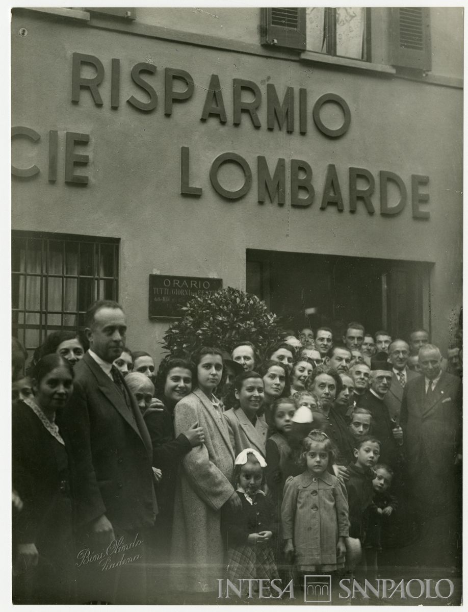 Foto di gruppo all'esterno della filiale Cariplo di Isola Dovarese, il giorno dell'inaugurazione; primo da destra il presidente Stefano Jacini, ottobre 1948 (Olindo Bini)