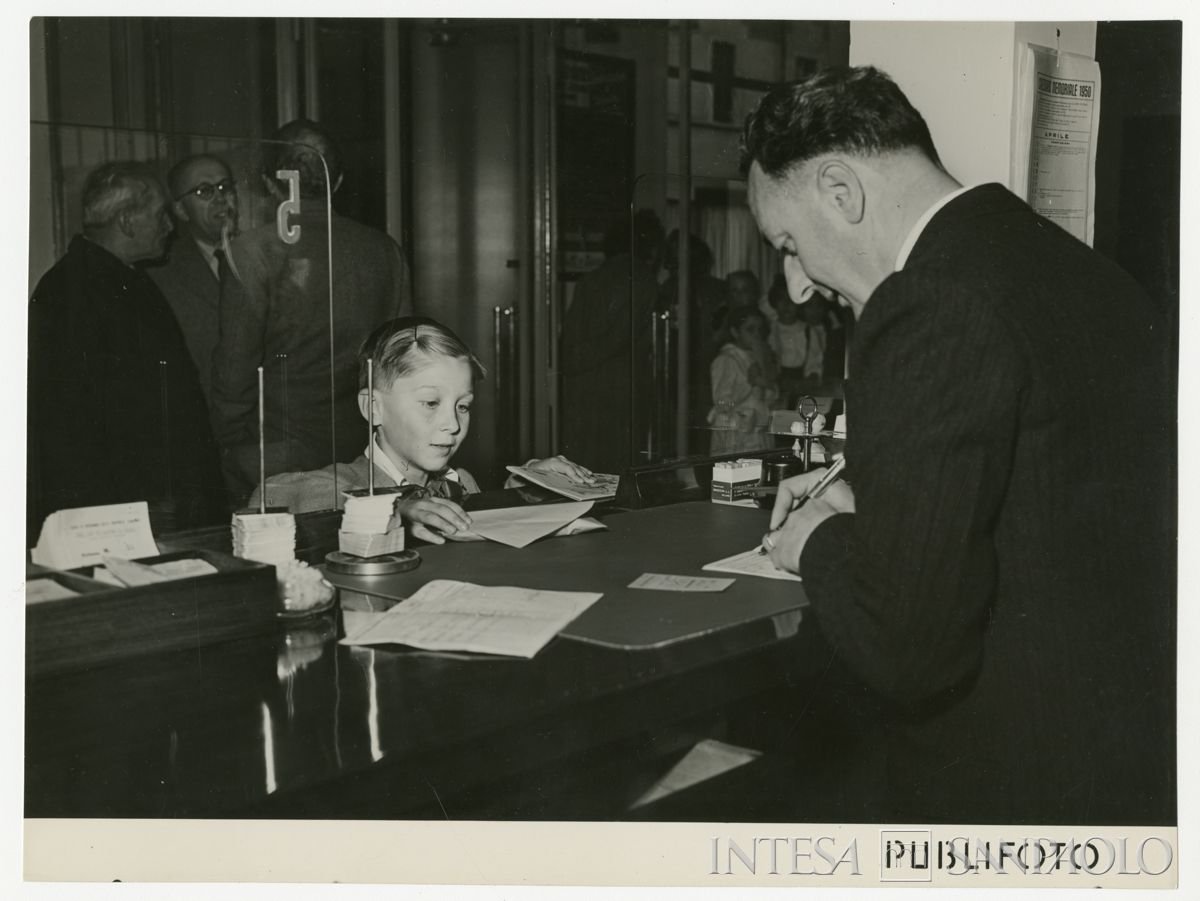 Apertura di un libretto di risparmio a un bambino, nel giorno dell'inaugurazione dell'agenzia 22 di Milano della Cariplo, in via Jacopino da Tradate, 15 aprile 1950 (Publifoto)