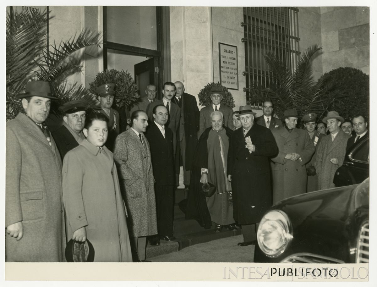 Foto di gruppo all'esterno della filiale Cariplo di Mortara nel giorno dell'inaugurazione; davanti al parroco, il presidente Stefano Jacini, 2 dicembre 1950 (Publifoto)