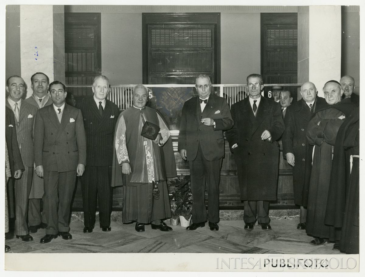 Foto di gruppo all'interno della filiale Cariplo di Mortara nel giorno dell'inaugurazione; al centro, accanto al parroco, il presidente Stefano Jacini, 2 dicembre 1950 (Publifoto)
