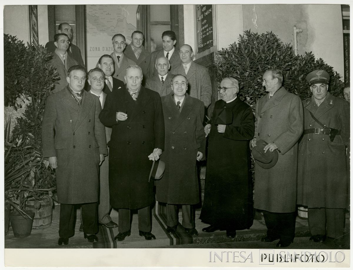 Foto di gruppo all'ingresso della filiale Cariplo di Paderno Dugnano, il giorno dell'inaugurazione; a sinistra, secondo dall'alto, l'ingegnere Capo Sandro Candiani, e in prima fila, terzo da sinistra, il presidente Stefano Jacini, 5 dicembre 1950 (Publifoto)