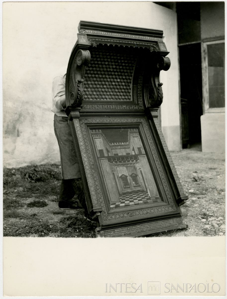 Rodendo Saiano, Abbazia di San Nicolò: stallo ligneo del coro tenuto da un addetto ai lavori, agosto 1964 (Foto Studio Mirino)