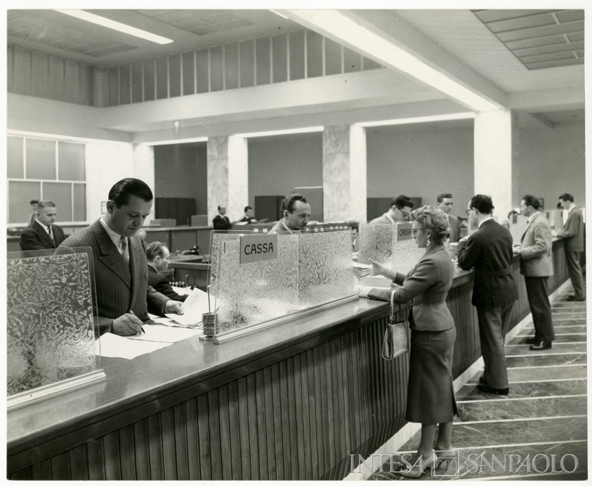Cariplo, impiegati e cliente in posa nel salone del pubblico dell'Agenzia 2 (Ticinese) di Milano, anni 1960 (Gino Battaglia)