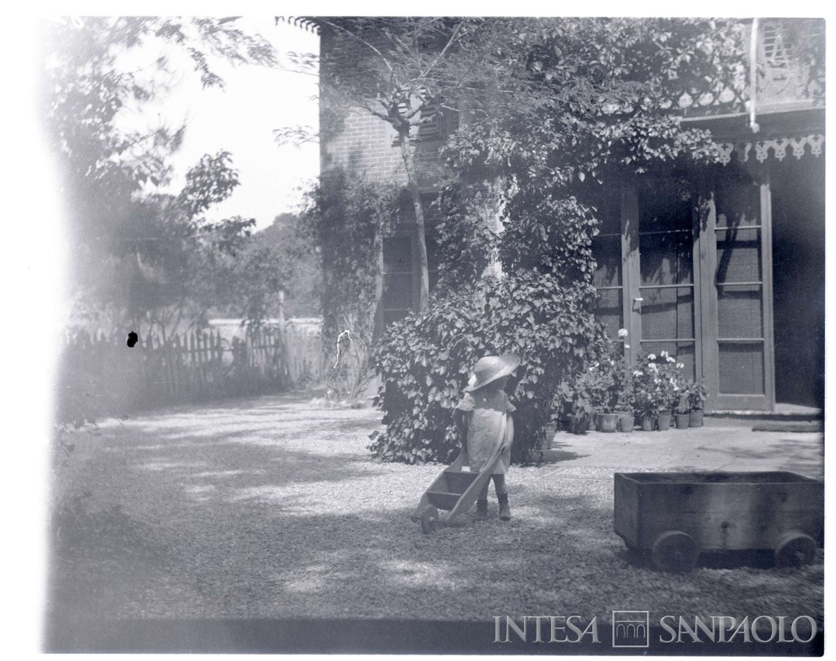 Nogara Johnny all'aperto davanti a casa con cariola, giugno 1903 (Bernardino Nogara)