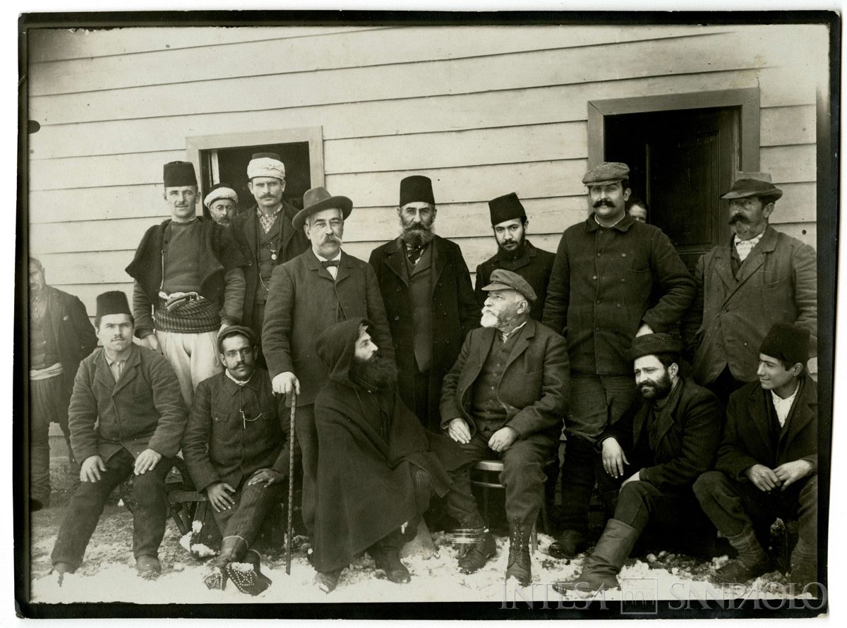 Ritratto di gruppo  dell'ingegner Roberto Paganini con il personale delle miniere davanti a un edificio, 1904 - 1914 (fotografo sconosciuto)