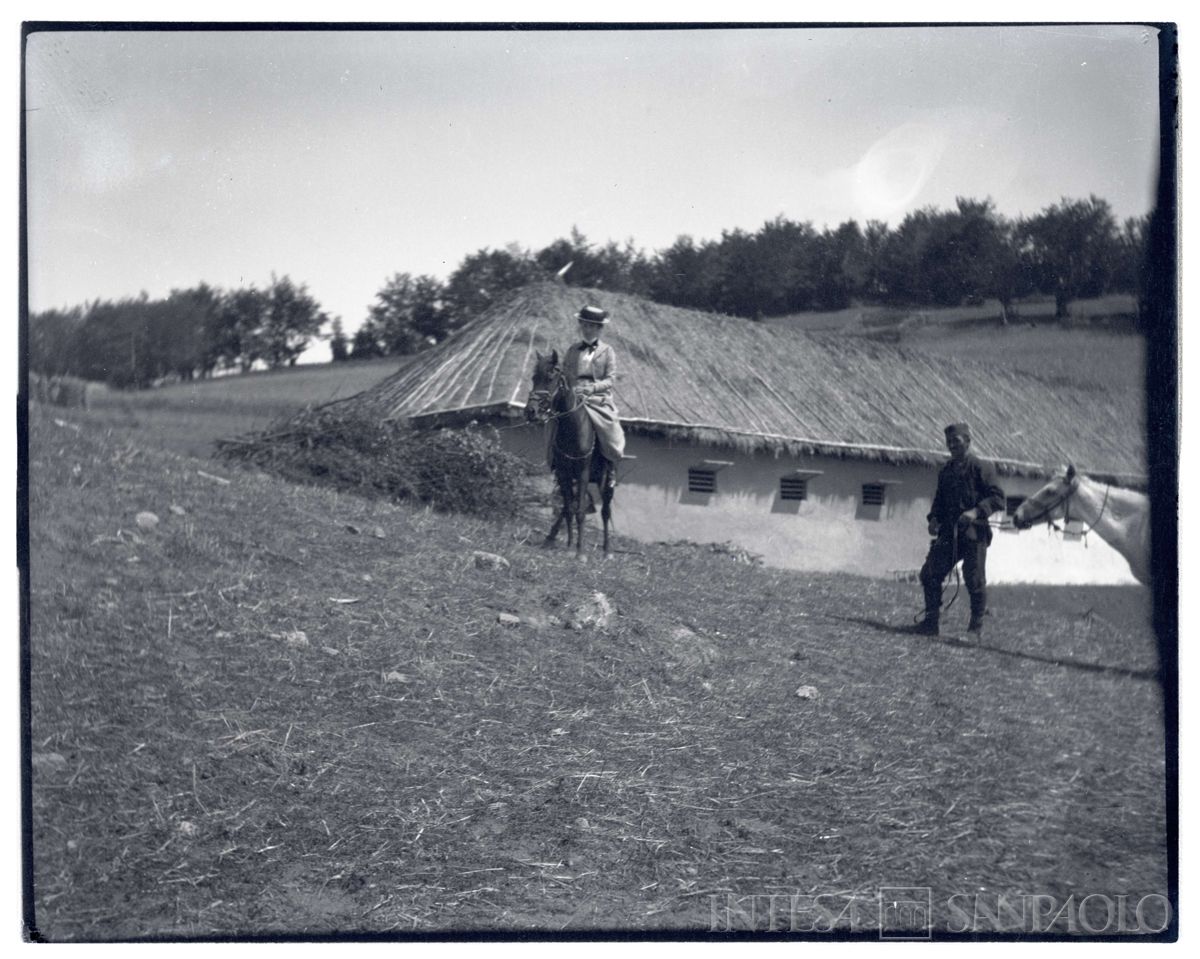 Ester Nogara a cavallo, davanti ad un edificio con tetto di paglia, 1905 circa (Bernardino Nogara)