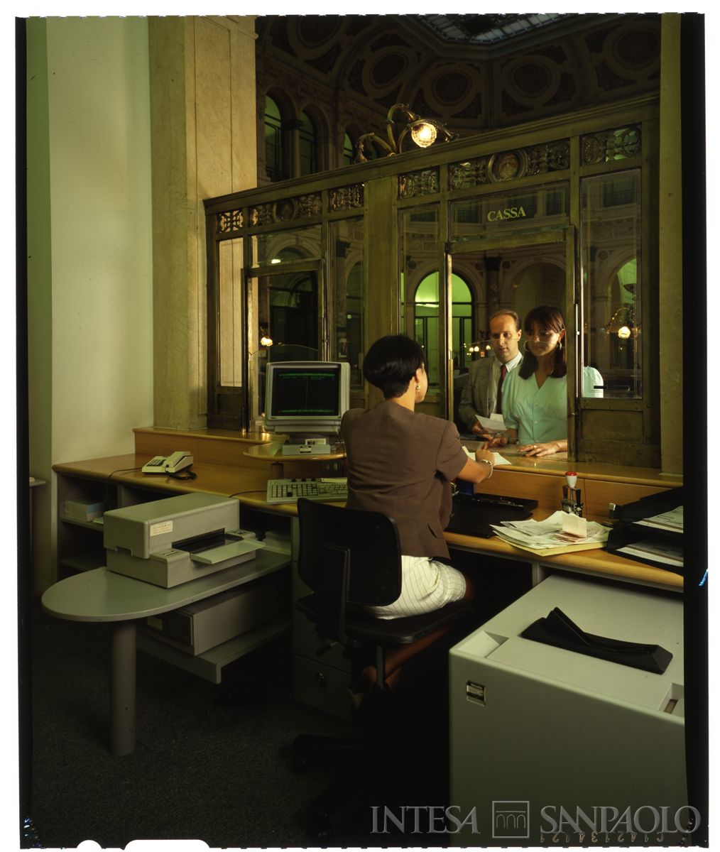 Palazzo di piazza della Scala 6, salone A: dettaglio di uno sportello con cliente e personale al lavoro, anni Novanta (foto di Immagine S.a.s)