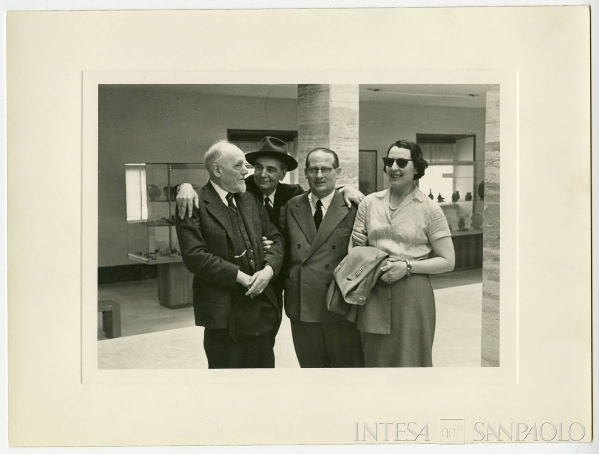 Gita di fine anno dell'Istituto Italiano per gli Studi Storici al Museo di Paestum. Da sinistra: Riccardo Ricciardi, Raffaele Mattioli, Giuseppe Lapreta e l'archeologa Paola Zancani Montuoro, 1956 (fotografia attribuita a Armando Andreassi)