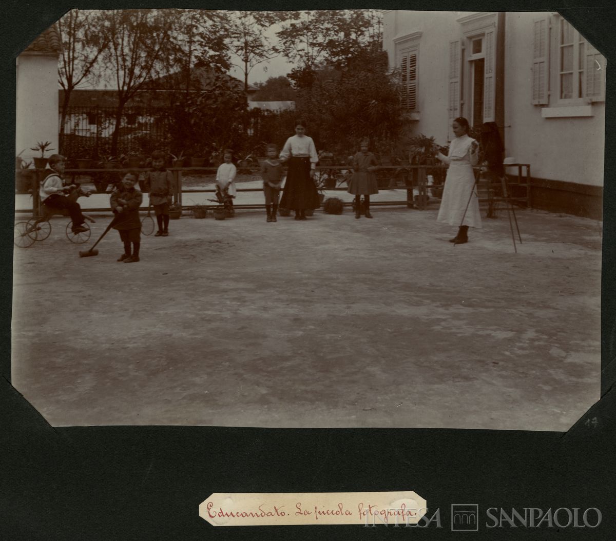 Istituto Canossiano italiano a Han-Kow (Cina), educandato: bambini durante il gioco mentre una bambina fotografa con il banco ottico, 1900 (fotografo sconosciuto)