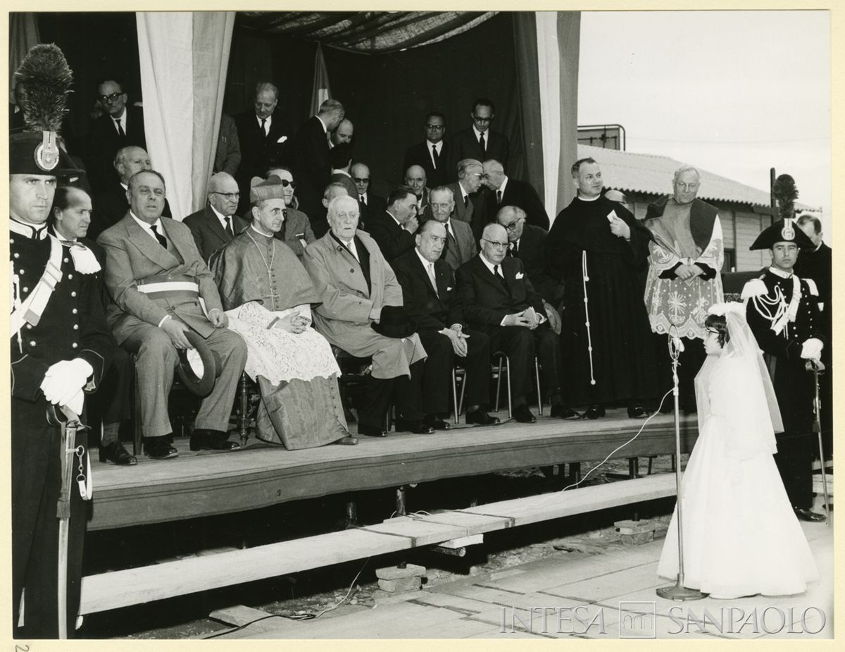 Cerimonia per la posa e la benedizione della prima pietra della Chiesa di San Gregorio Barbarigo a Milano; da destra, seduti in prima fila, i dirigenti del Banco Ambrosiano Gino Brusati, Carlo Alessandro Canesi, Tommaso Gallarati Scotti e il vice-sindaco di Milano Luigi Meda, 23 maggio 1963 (Foto Fidigati)