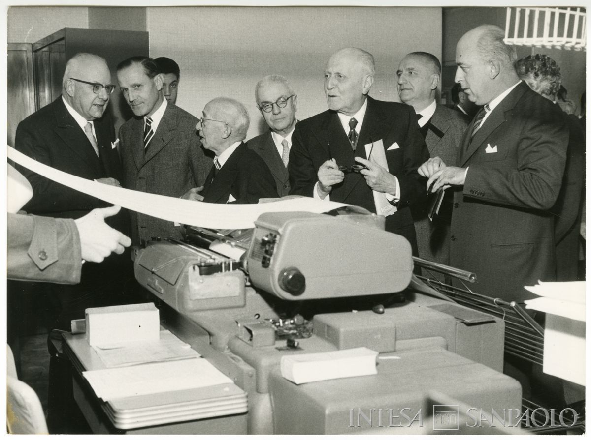 Nuovo macchinario del centro elettro-contabile del Banco Ambrosiano di Milano mostrato al presidente dell'Istituto Tommaso Gallarati Scotti, terzo da destra; segue poco dietro Giuseppe Cavazzana, 10 dicembre 1958 (Publifoto)