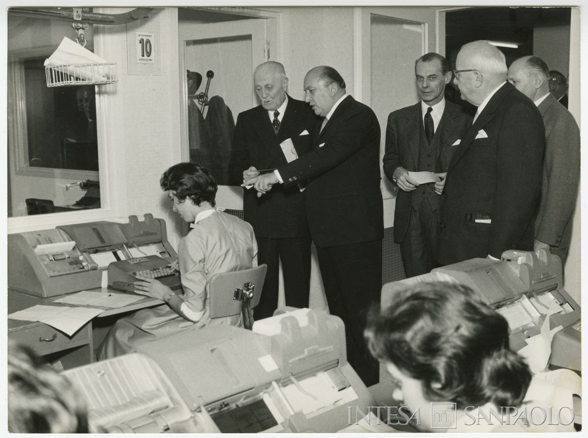 Visita ai locali del centro elettro-contabile del Banco Ambrosiano di Milano con personale femminile al lavoro; in piedi da sinistra il presidente dell'Istituto Tommaso Gallarati Scotti e Carlo Alessandro Canesi, 10 dicembre 1958 (Publifoto)