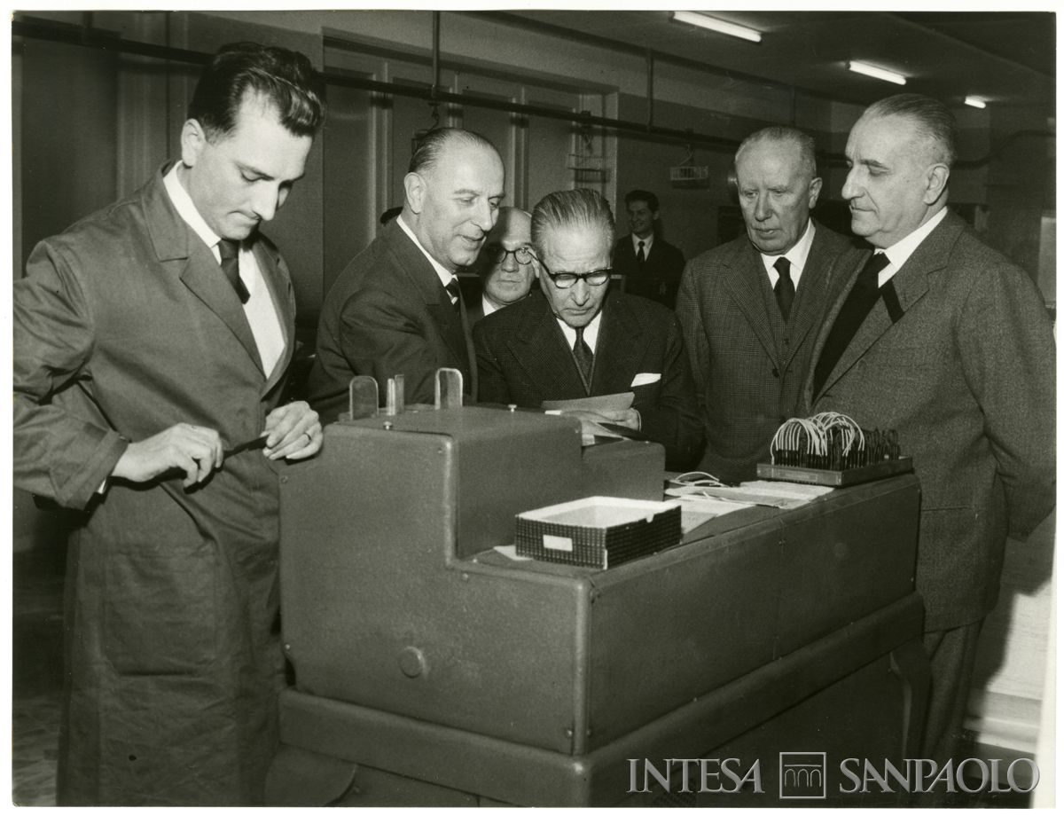 Nuovo macchinario del centro elettro-contabile del Banco Ambrosiano di Milano; in primo piano, terzo da dx, Francesco Bianchi, 10 dicembre 1958 (Publifoto)