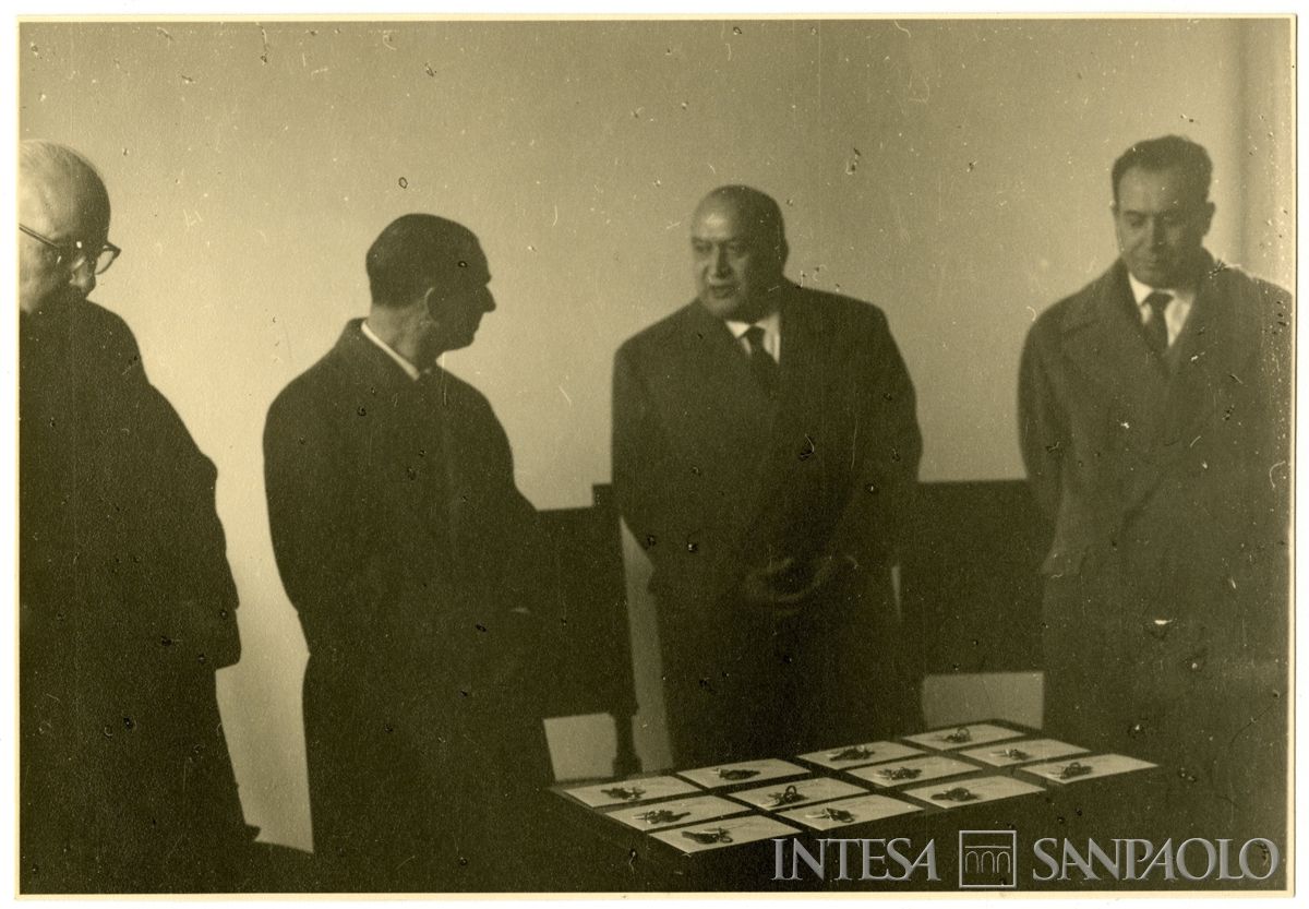 Autorità per la consegna ai dipendenti beneficiari delle chiavi degli appartamenti delle case del piano INA-CASA del Banco Ambrosiano a Torino; Luigi Brusati è il primo a sinistra, Carlo Alessandro Canesi secondo da destra, 24 marzo 1960 (fotografo sconosciuto)