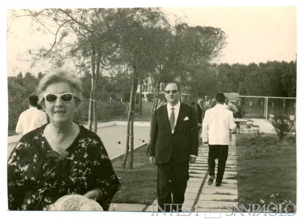 Il presidente dell'IMI Stefano Siglienti (al centro) e la moglie Ines Berlinguer (in primo piano a sinistra) accanto alla piscina del circolo sportivo dell'IMI, Roma, post giugno 1961 (fotografo sconosciuto)