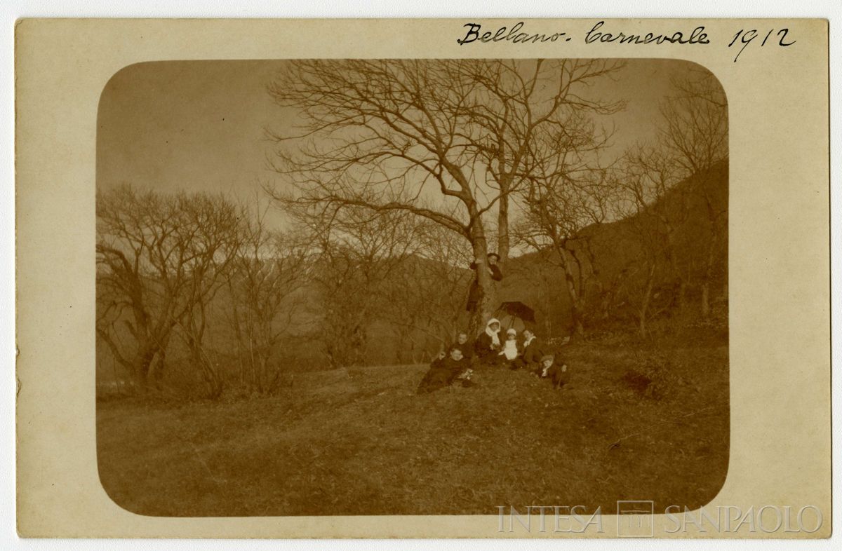 Nogara Ester con Josy e Paolo e alcuni zii all'aperto a Bellano durante il carnevale, 1912 (fotografo sconosciuto)