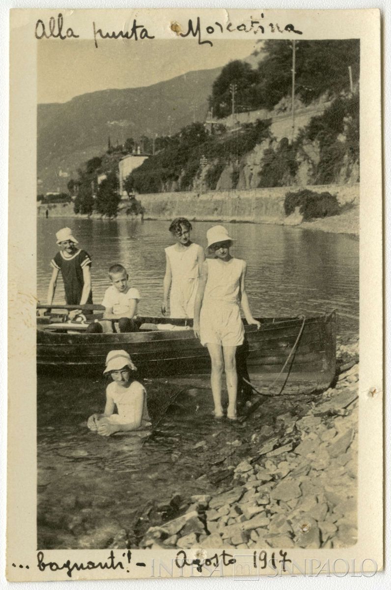 Nogara Giulia, Paolo e altri bambini non identificati accanto a una barca, alla Punta Morcatina, vicino a Bellano, agosto 1917 (fotografo sconosciuto)