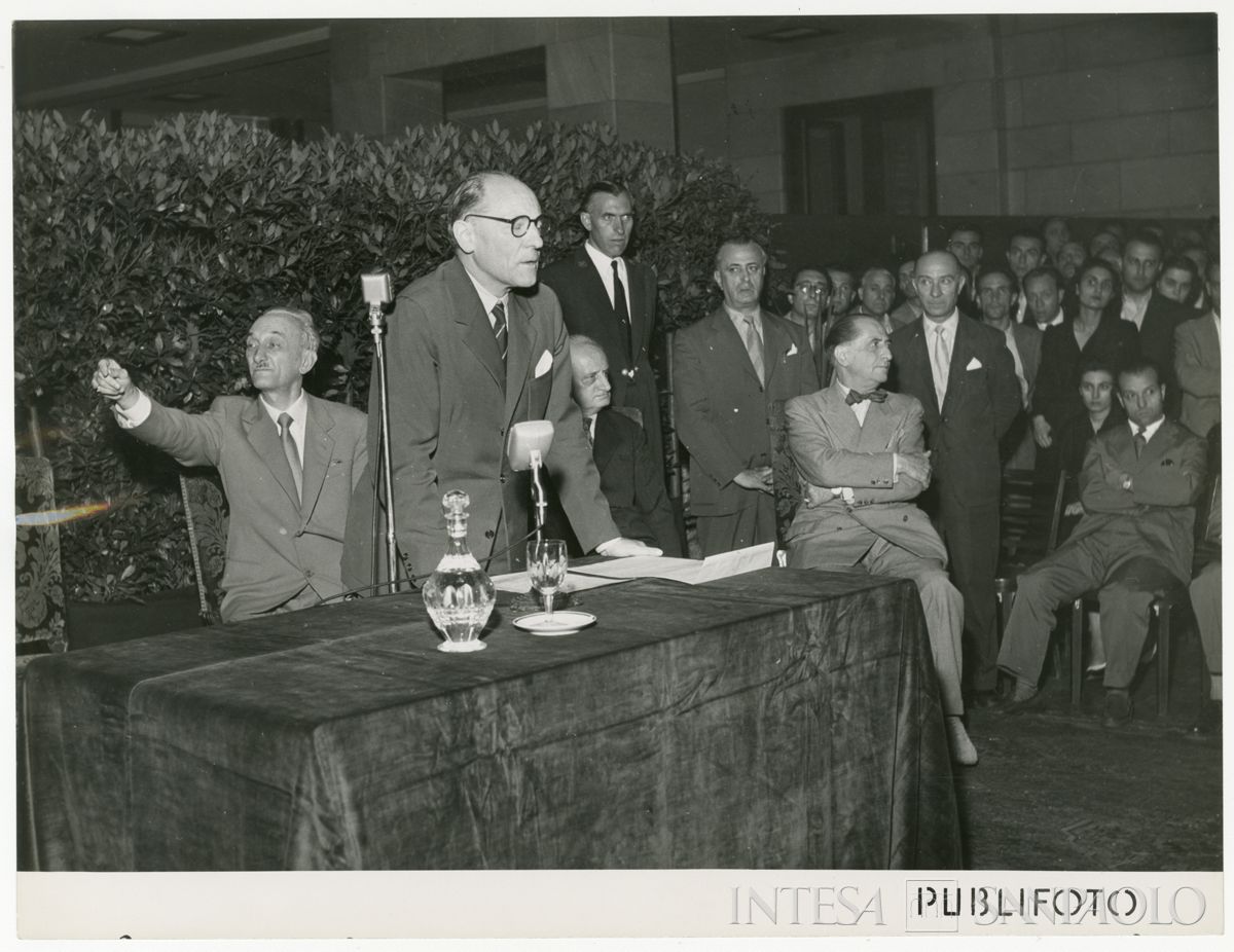 Commemorazione dello scomparso presidente Cariplo Stefano Jacini all'interno del Palazzo delle Colonne; intervento del vice presidente di Jacini Cesare Chiodi; alle sue spalle, a sinistra Dones, a destra Giuseppe De Amicis, 4 luglio 1952 (Publifoto)