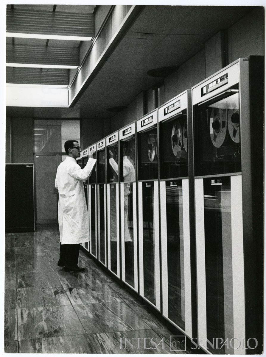 Cariplo, Centro Elettronico (C.E.) di Milano, Via Verdi 11: salone dei calcolatori con personale al lavoro, 1969 (Fotostile)