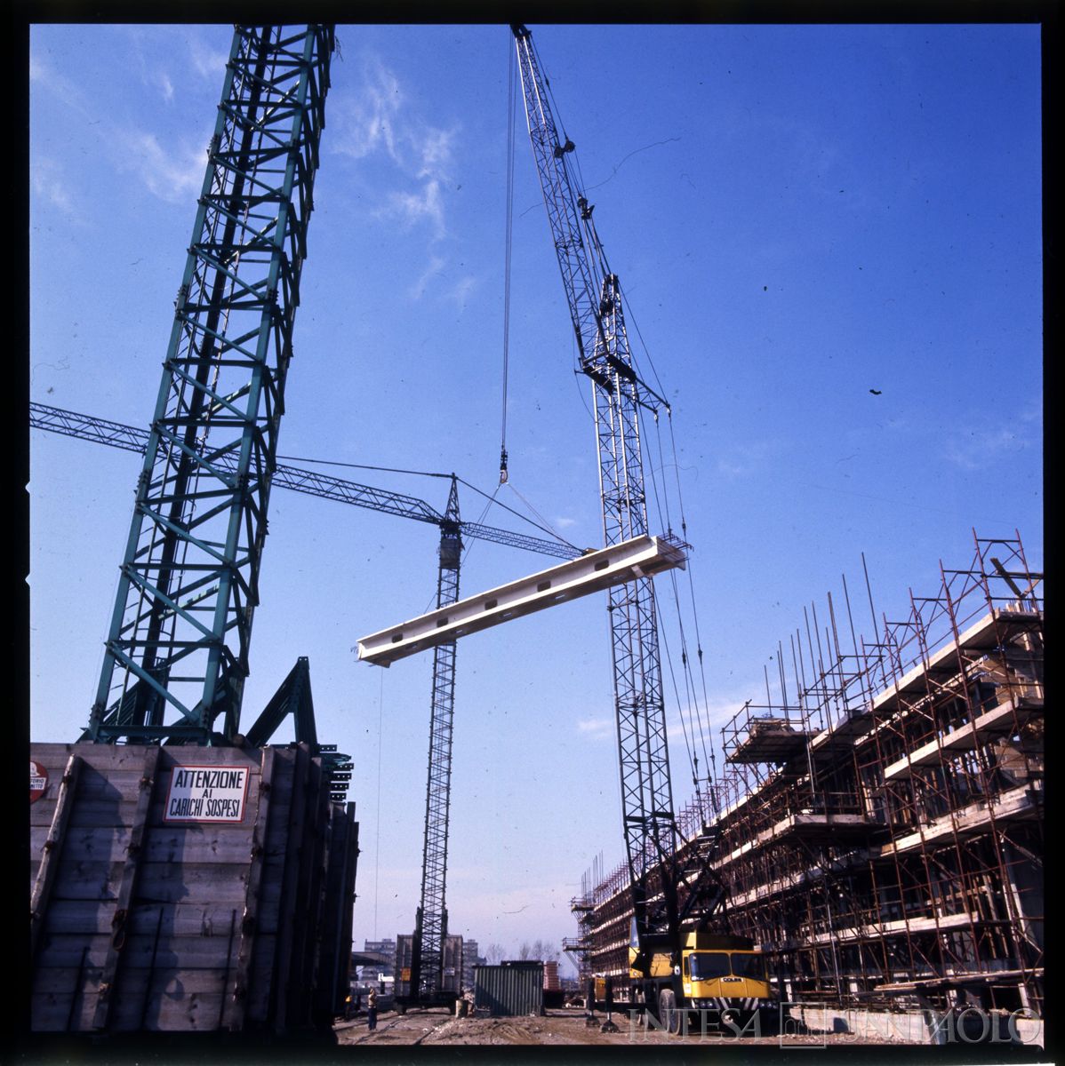 Cariplo, Centro Elettronico (C.E.): Milano, Via Lorenteggio, particolare del collocamento in opera di travi o porzione di solaio prefabbricato, 1976-1977 (fotografo sconosciuto)