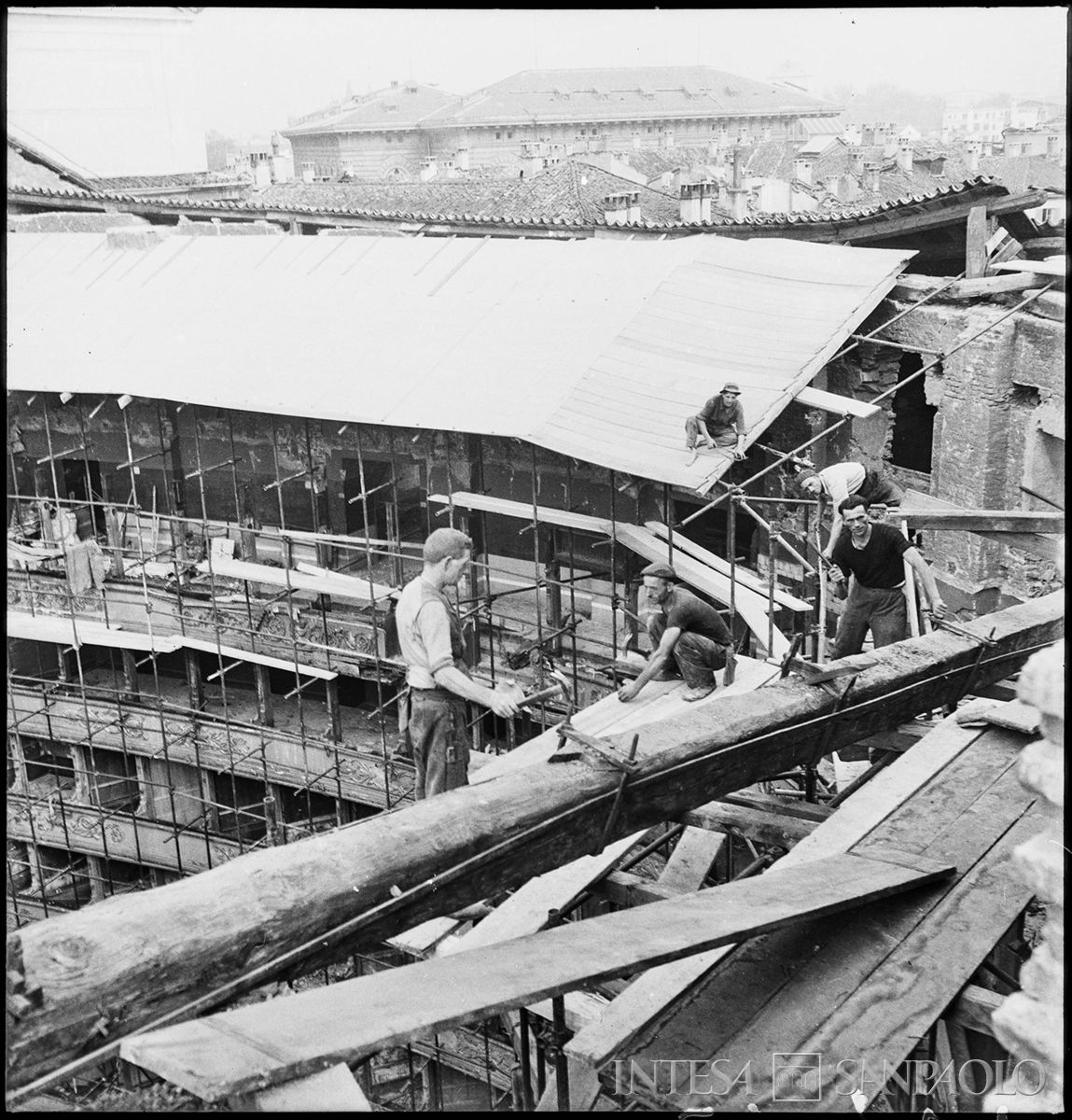 Operai al lavoro per la realizzazione di una copertura provvisoria del Teatro alla Scala di Milano, il cui tetto è crollato a causa dei bombardamenti su Milano, 16 agosto - 31 agosto 1943 (Publifoto)