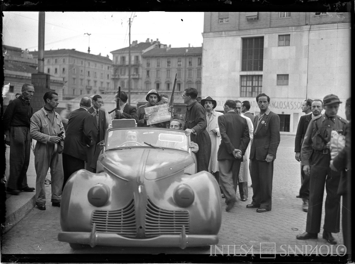 Un componente del Corpo volontari della libertà (C.V.L.) mostra la prima pagina di "L'Italia libera" con la notizia dell'insurrezione armata, 26 aprile 1945. La mattina del 26 aprile il quotidiano è stato il primo ad arrivare tra le mani dei milanesi. Fotografia di Publifoto