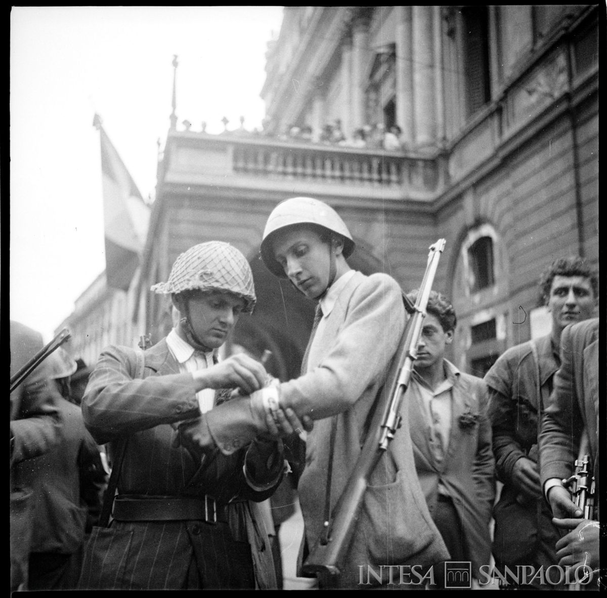 Due componenti del Corpo volontari della libertà (C.V.L.) in piazza della Scala a Milano nella prima giornata di insurrezione armata, 26 aprile 1945. Fotografia di Publifoto