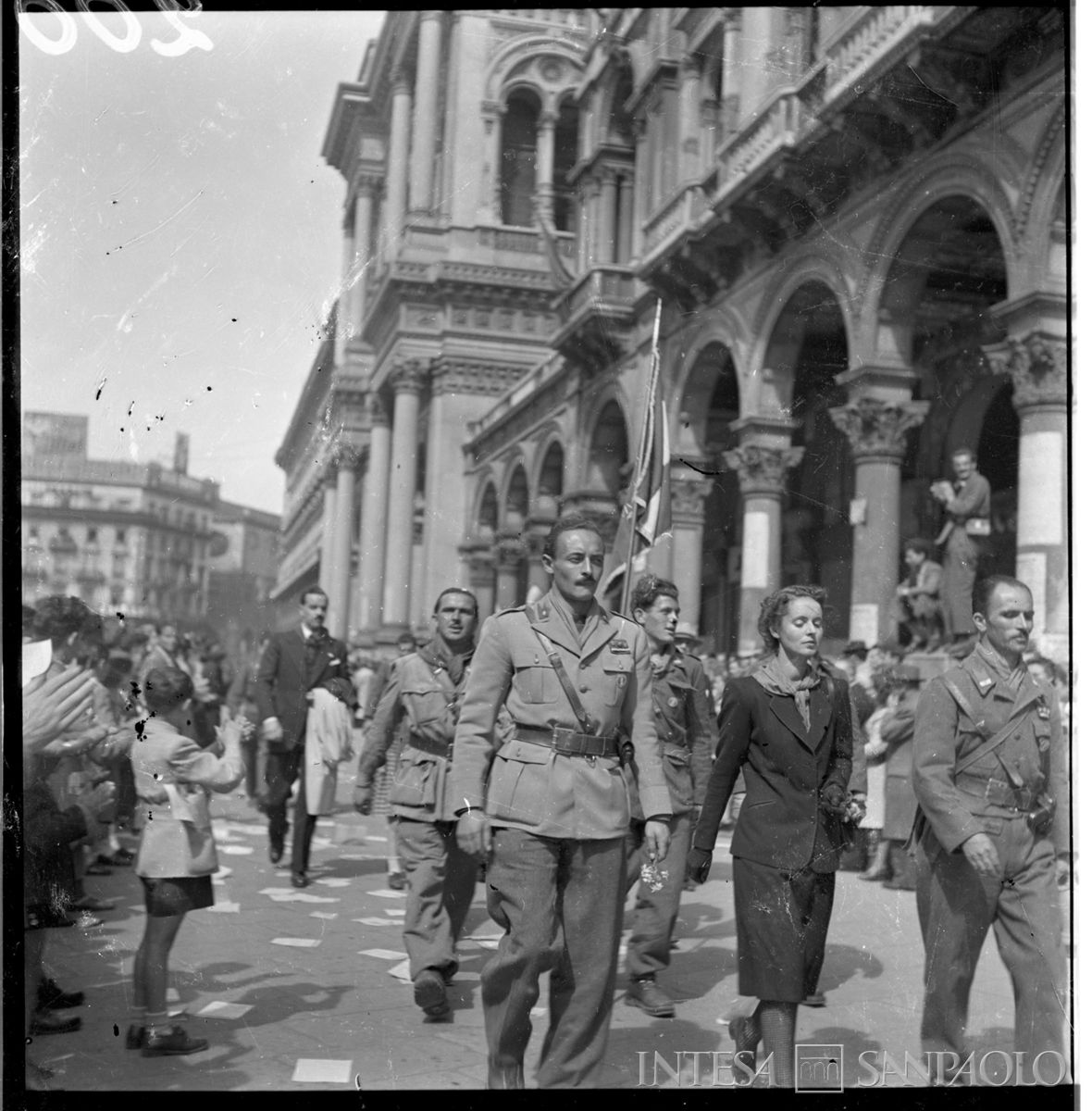 Sfilata delle formazioni partigiane convenute in Milano, 6 maggio 1945. Al centro Giuliana Gadola con, a sinistra, Bruno Rutto, che guidò la Divisione Alpina intestata al marito, Filippo Beltrami, partigiano che perse la vita a Megolo il 13 febbraio 1944. Fotografia di Publifoto