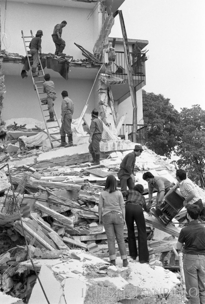 Vigili del fuoco e civili al lavoro su un edificio danneggiato dal terremoto del 6 maggio 1976. Fotografia di Lucio Berzioli - Publifoto