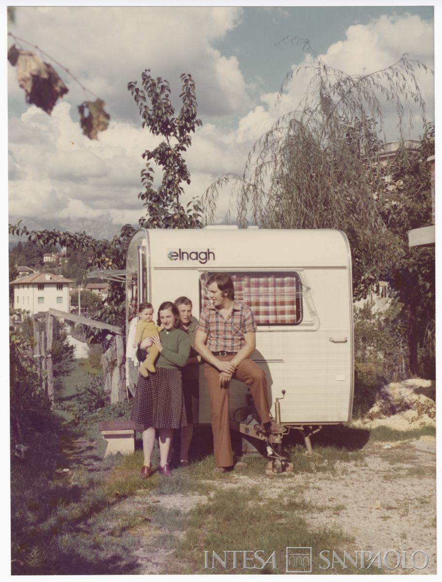 Una famiglia sfollata davanti alla roulotte donata dalla Banca Cattolica del Veneto, post 6 maggio 1976. Archivio Storico Intesa Sanpaolo, sezione fotografica BCV