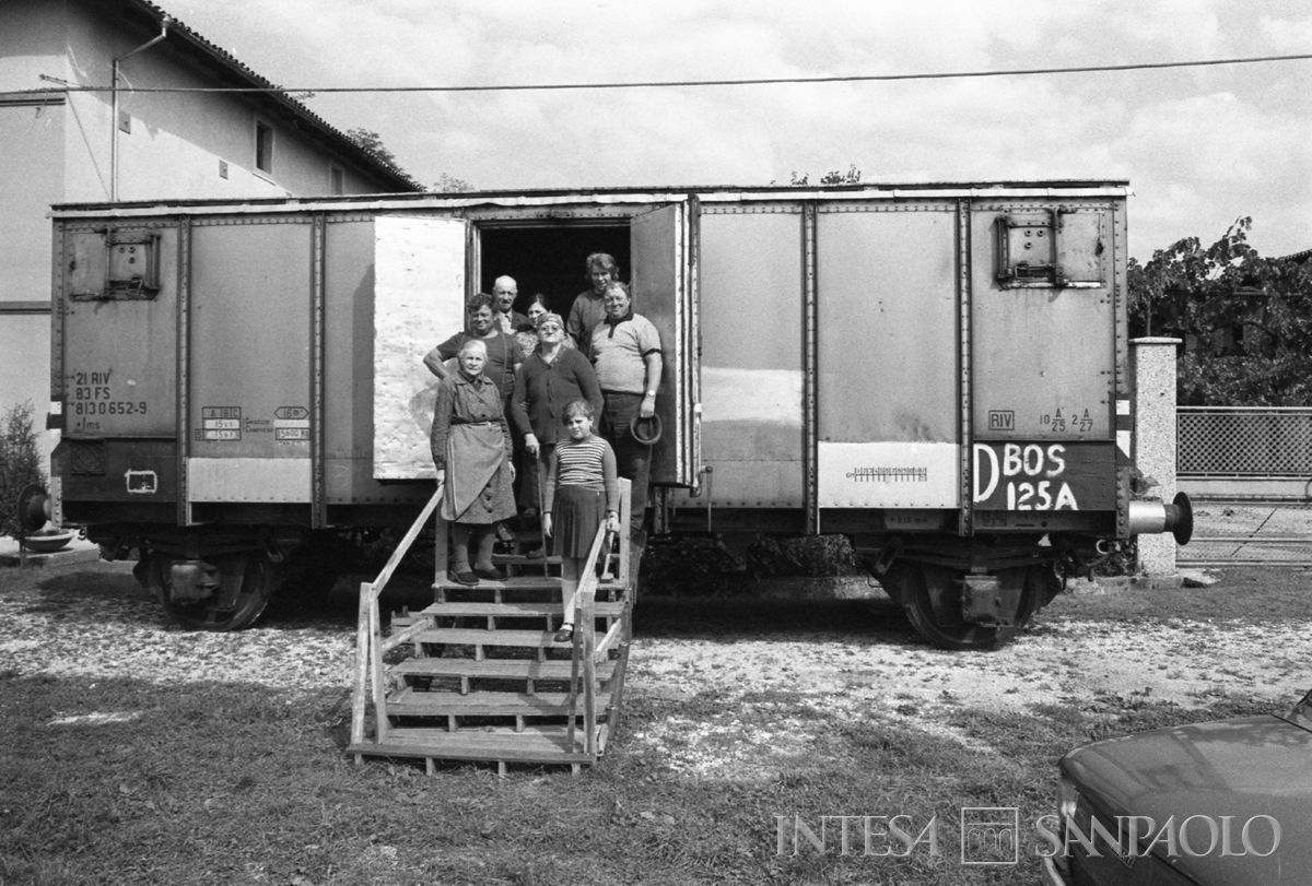 ​Una famiglia davanti al vagone ferroviario adibito ad abitazione in una delle località colpita dal terremoto in Friuli, maggio - s​ettembre 1976