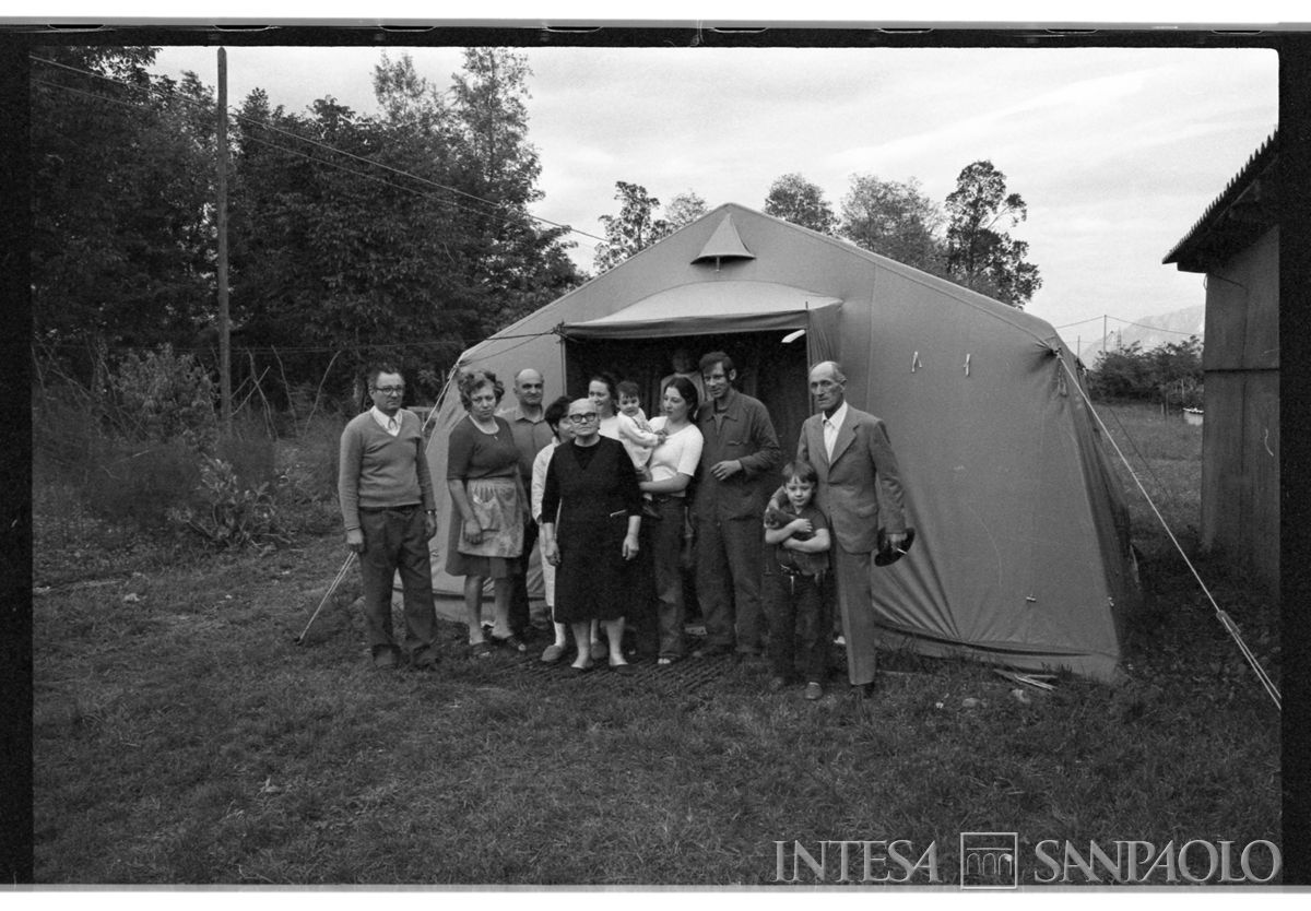 Una famiglia davanti ad una tenda da campo in una delle località del Friuli colpite dal terremoto, maggio-settembre 1976 Fotografia di Lucio Berzioli - Publifoto