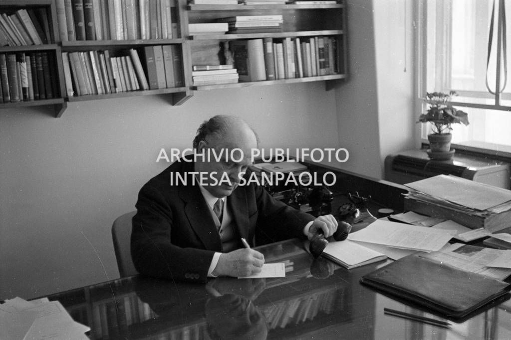 Adriano Olivetti seduto alla scrivania con la cornetta del telefono in mano<br>453484