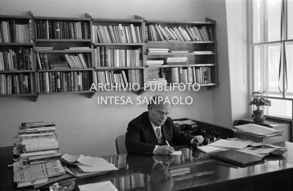 Adriano Olivetti seduto alla scrivania con la cornetta del telefono in mano<br>453485