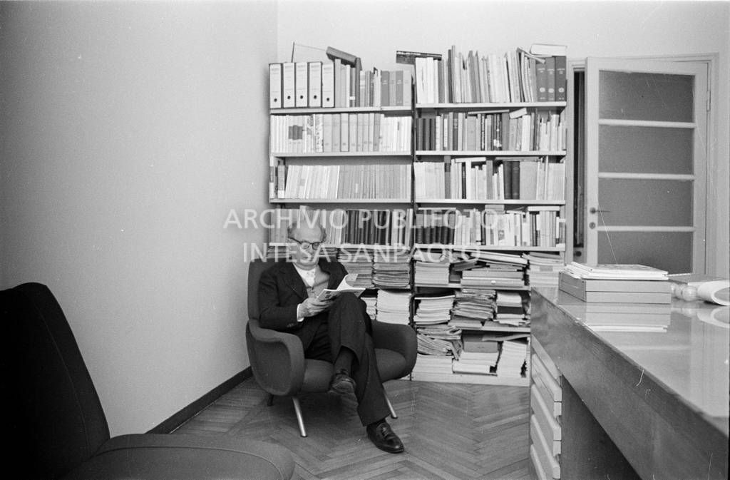 Adriano Olivetti, seduto in poltrona, con una rivista<br>453492