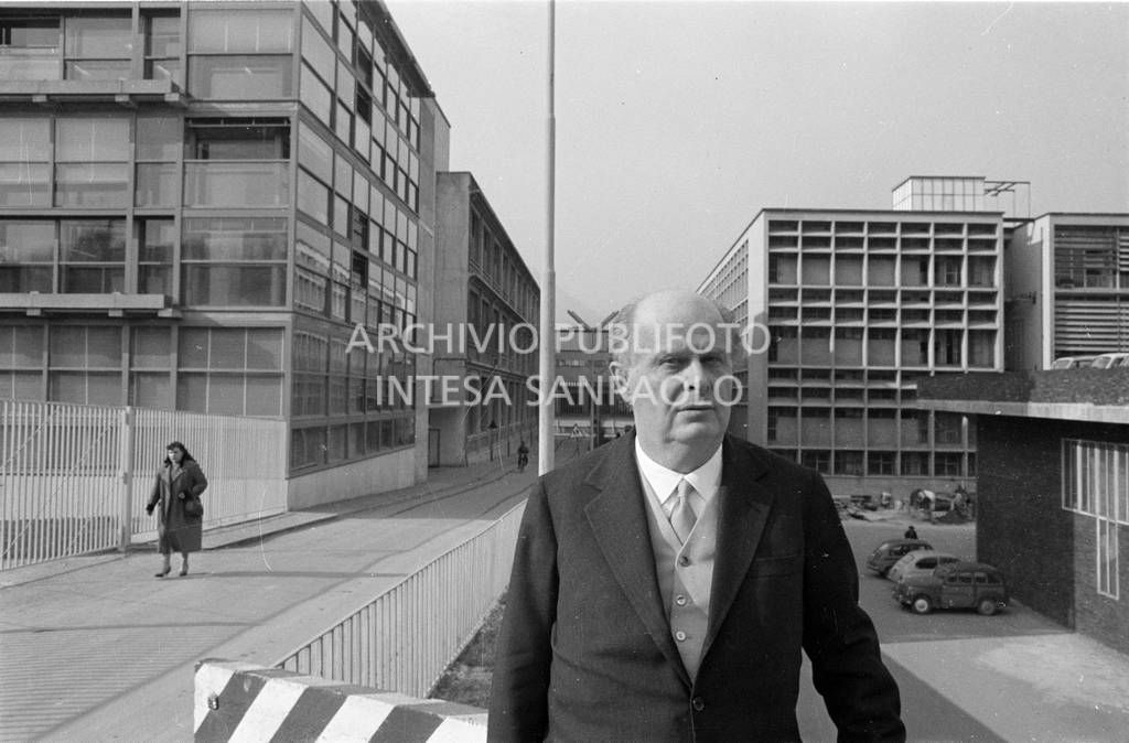 Adriano Olivetti ritratto con gli edifici industriali alle spalle<br>453495