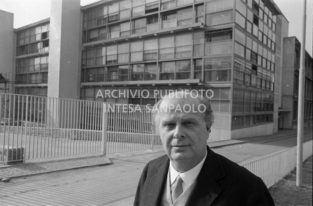 Adriano Olivetti ritratto con gli edifici industriali alle spalle<br>453513