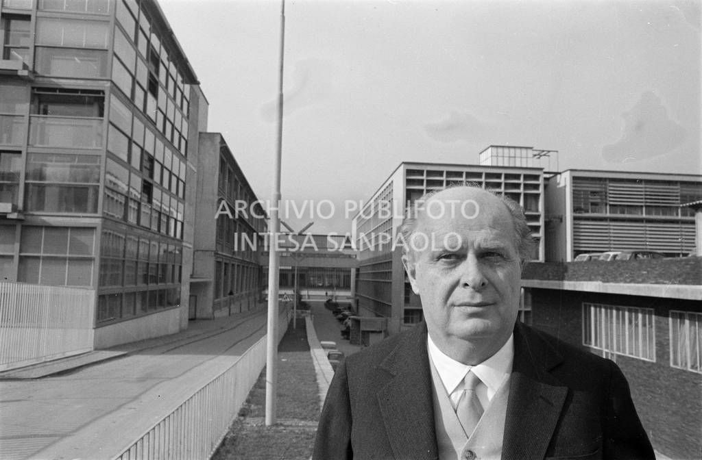 Adriano Olivetti ritratto con gli edifici industriali alle spalle<br>453514