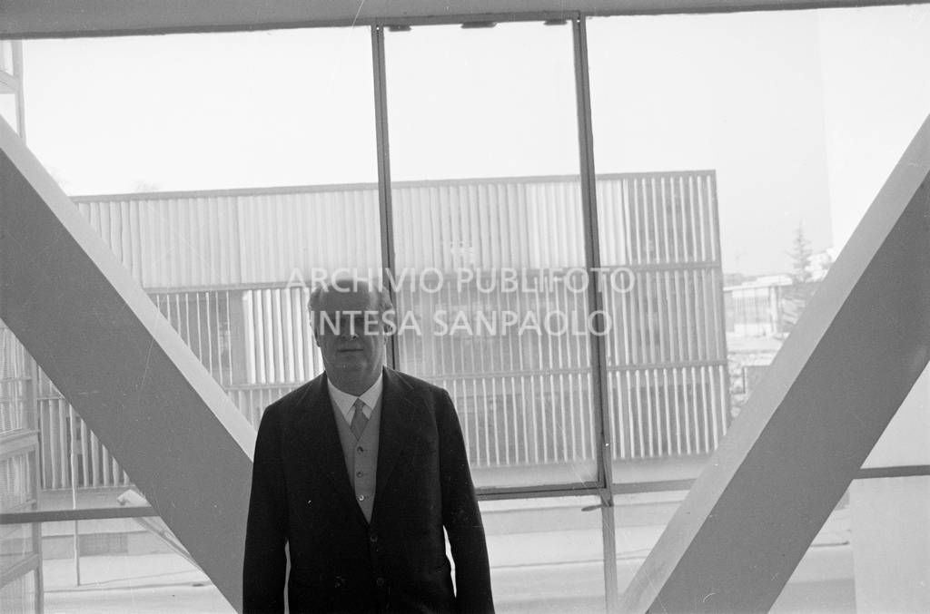 Adriano Olivetti ritratto davanti a una vetrata<br>453523