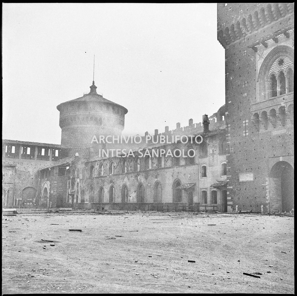 Scorcio della facciata del Cortile d'Armi del Castello Sforzesco di Milano, gravemente danneggiata dai bombardamenti. Sullo sfondo il Torrione del Carmine e a destra la Torre del Filarete
