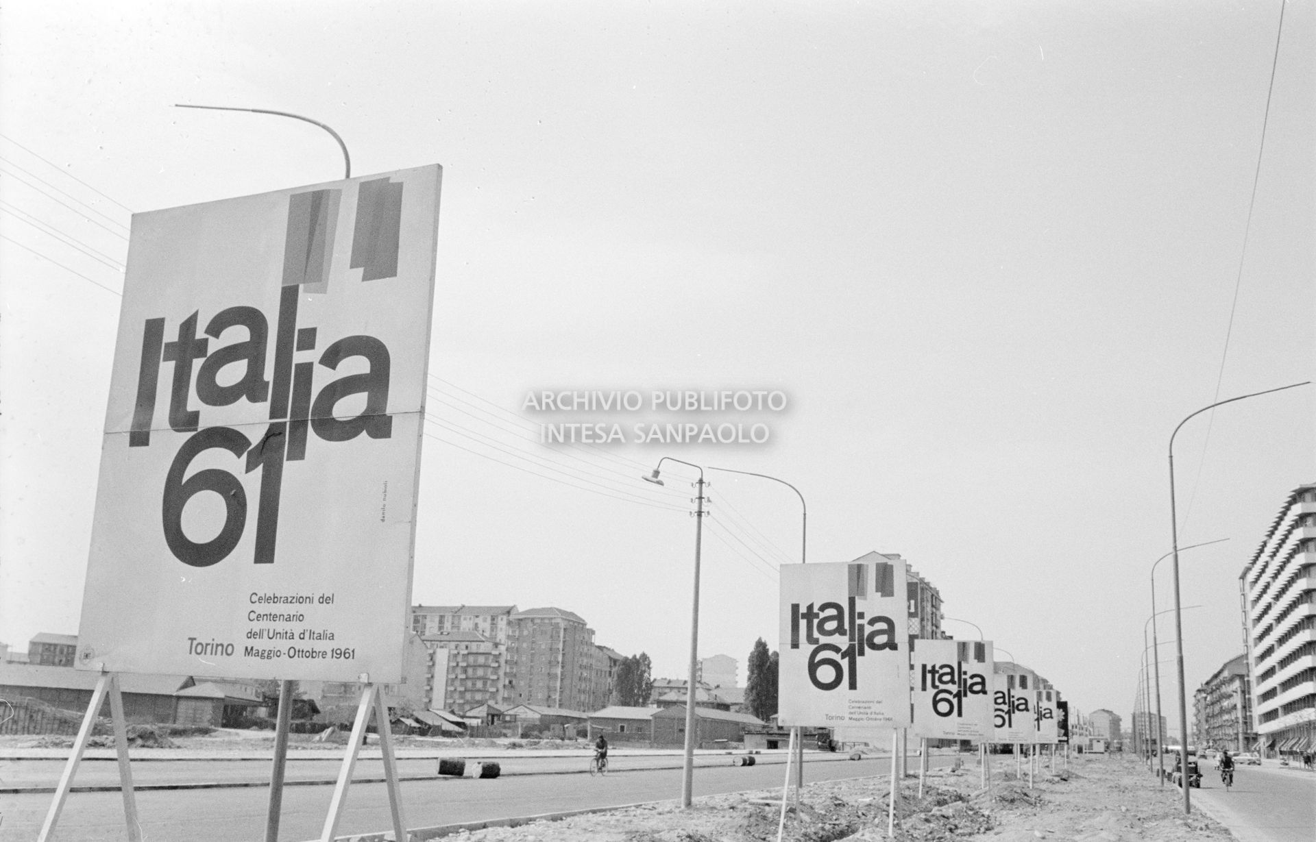 Manifesti pubblicitari con la scritta  "Italia 61" in un viale di Torino in vista dell'Esposizione Internazionale del Lavoro organizzata per celebrare il centenario dell'Unità d'Italia