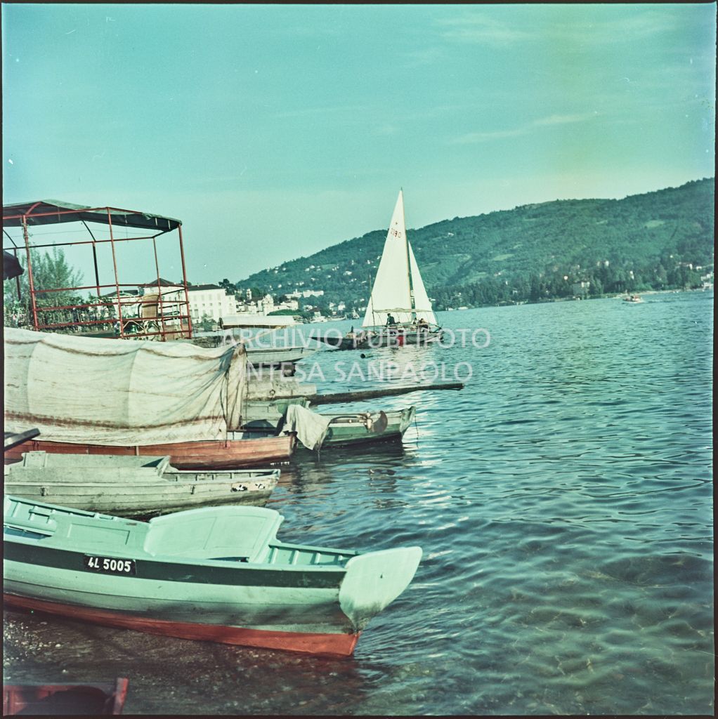 Vista di imbarcazioni e di una piattaforma con tavolini sulla riva dell'Isola dei Pescatori sul lago Maggiore<br>332