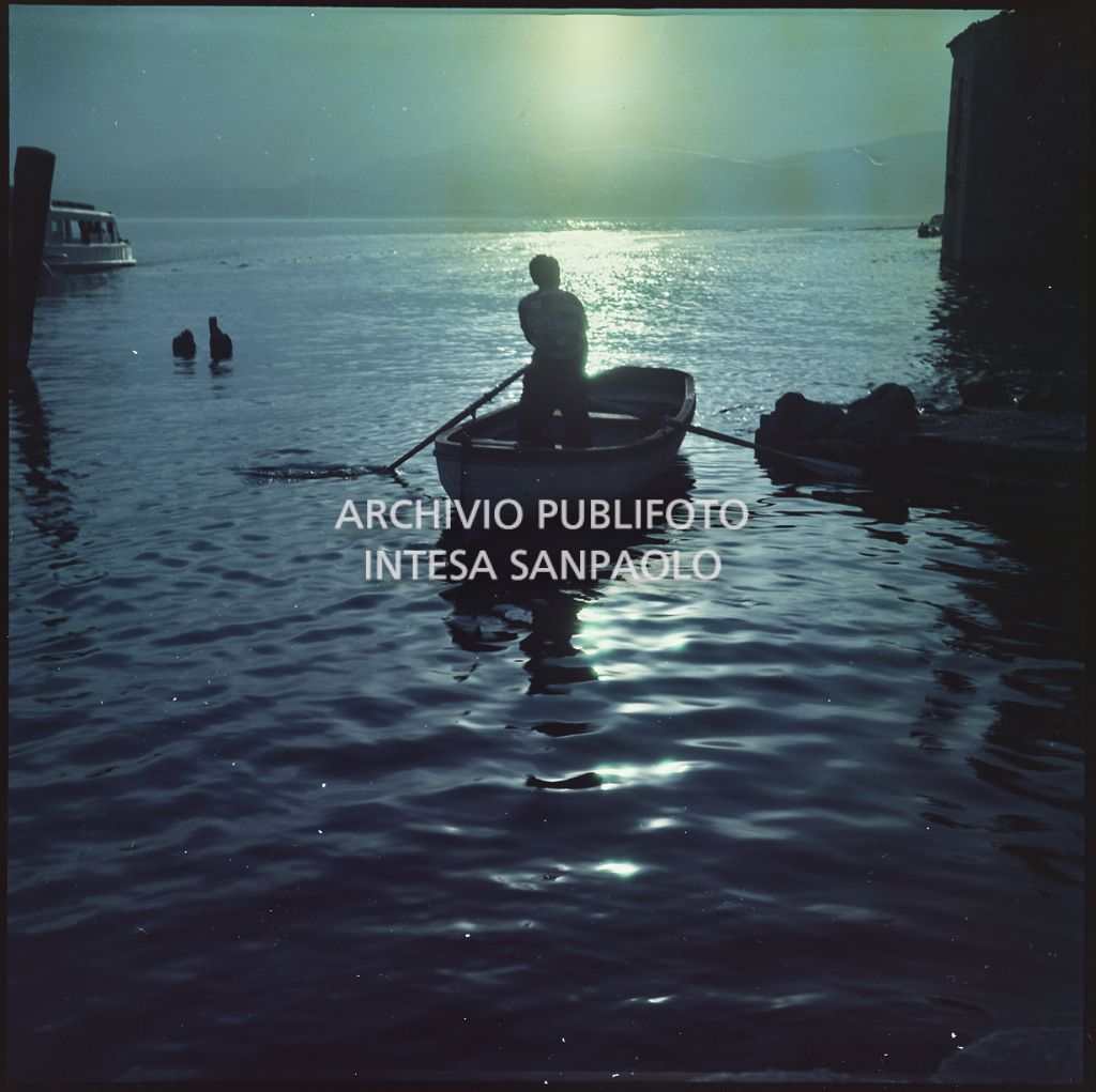 Uomo su una barca a remi al tramonto<br>369