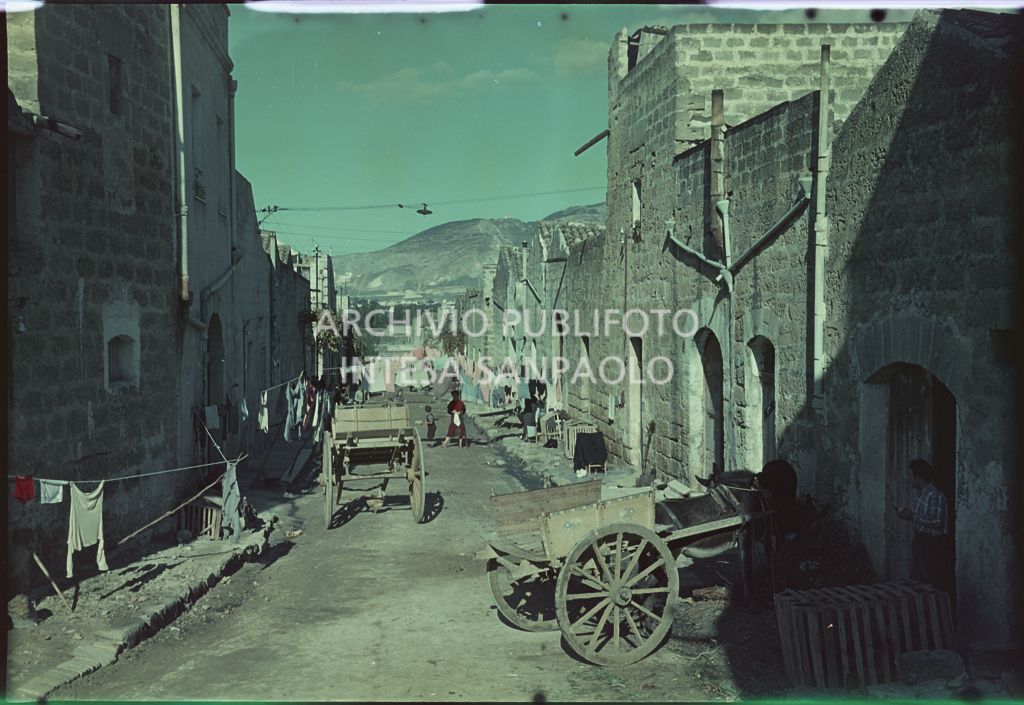 Una strada con panni stesi e carretti in località non identificata<br>401