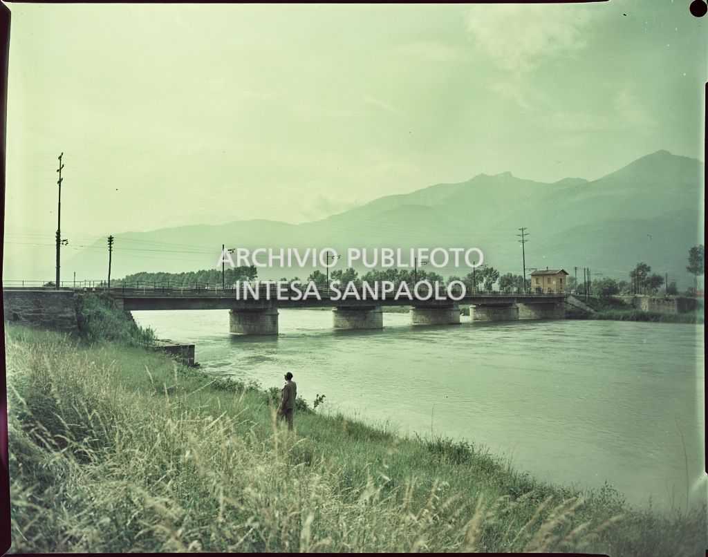 Ponte su un fiume in piena non identificato. Nel campo antistante un uomo<br>1528