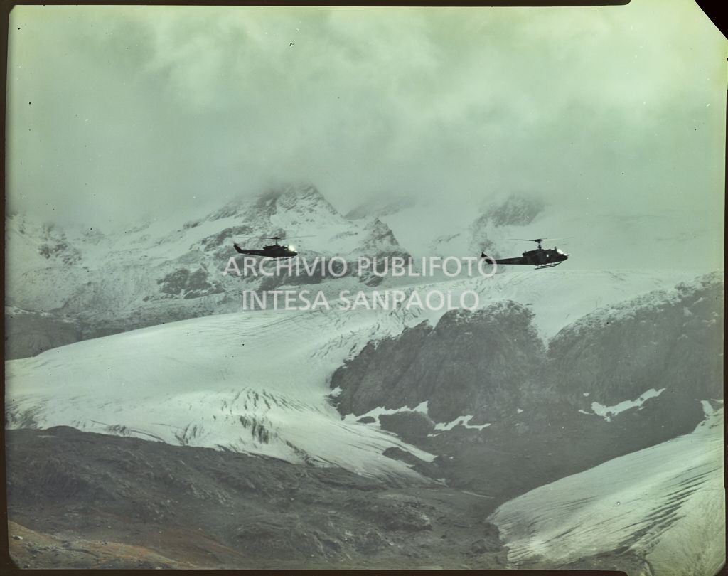 Due elicotteri militari in volo sopra le montagne innevate<br>5902