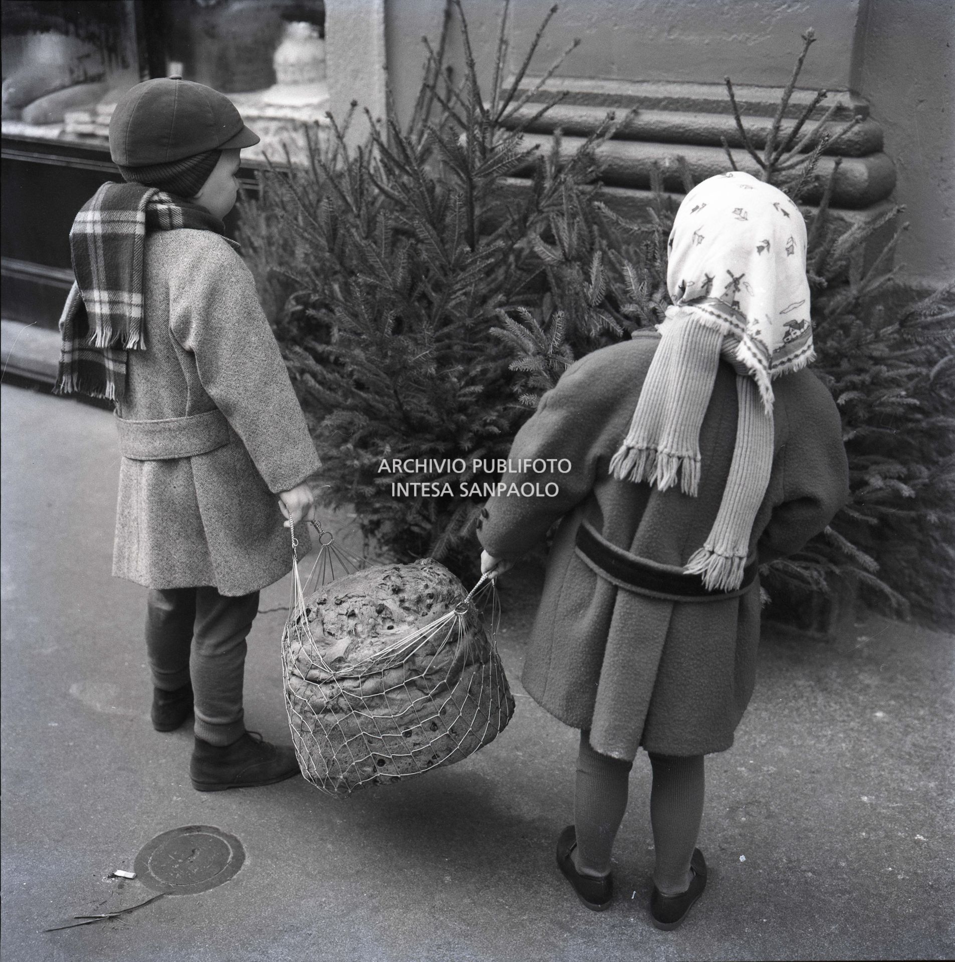 Due bambini trasportano un panettone<br>600255