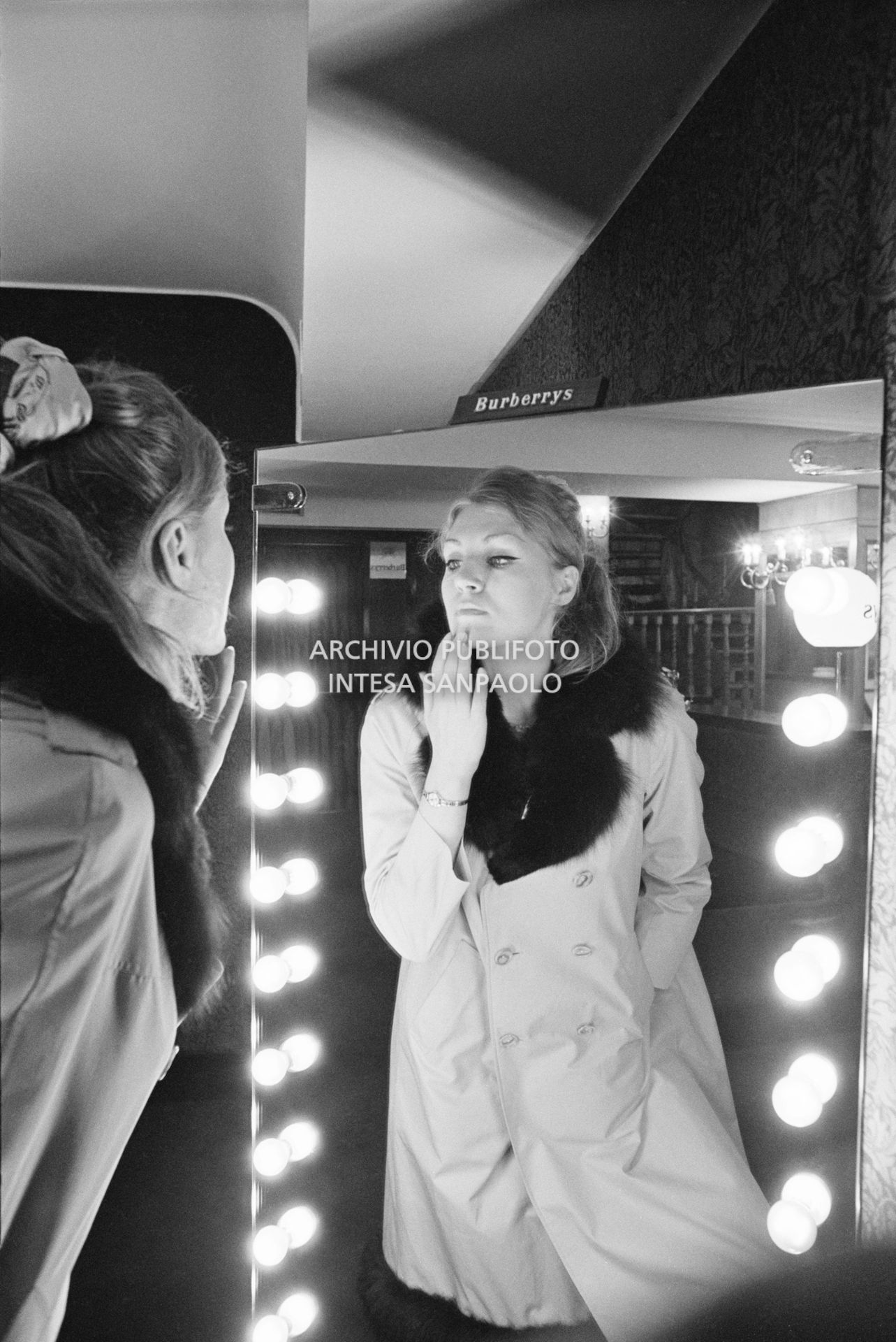 Anna German, con indosso un trench con l'interno in pelliccia, si specchia al negozio Burberrys'<br>727771/8